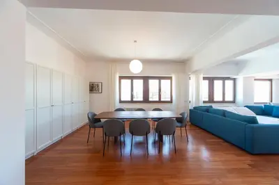 a living room with a blue couch and a table and chairs at Cardinal Mistrangelo - next to the metro station, large and comfortable penthouse with terrace in Rome
