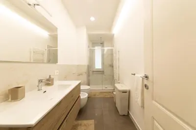 a white bathroom with a sink and a toilet at Barca House in Rome