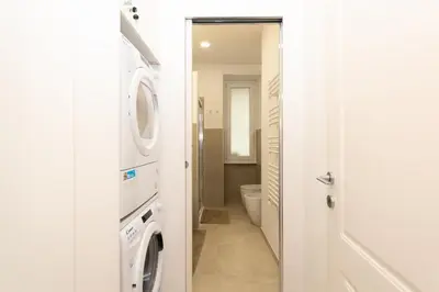 a bathroom with a washer and dryer next to a toilet at Barca House in Rome