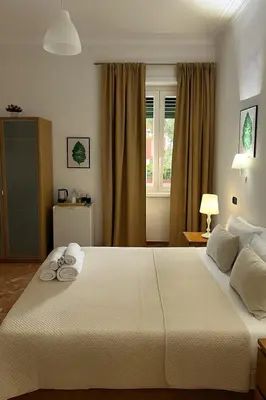 a bedroom with a large white bed with towels on it at Colosseo Rooms Rome in Rome
