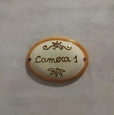 a sign with the name comica on a wall at Colosseo Rooms Rome in Rome