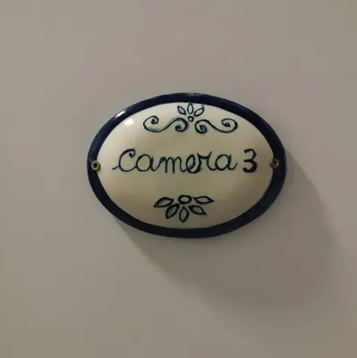a sign that says comuna three on a wall at Colosseo Rooms Rome in Rome
