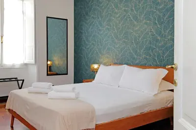 a bedroom with a large white bed with a blue wall at 4BNB - Vittorio Emanuele Apartment in Rome