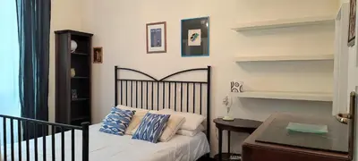 a bedroom with a bed and a table and shelves at Trasteverino in Rome