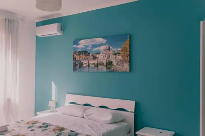 a bedroom with a blue wall with a bed at AMA Roma 5 minuti dal Colosseo in Rome
