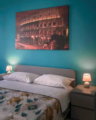 a bedroom with a bed with a painting on the wall at AMA Roma 5 minuti dal Colosseo in Rome