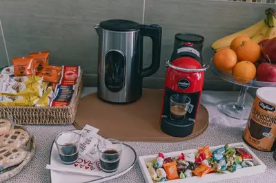a table with food and drinks and a coffee maker at AMA Roma 5 minuti dal Colosseo in Rome