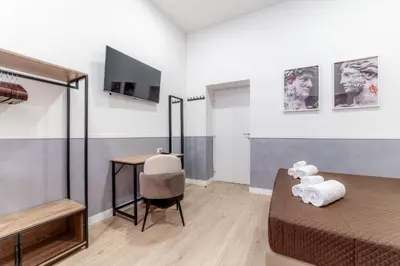 a bedroom with a bed and a desk and a television at Bello Urban Boutique - Golden Keys Collection in Rome