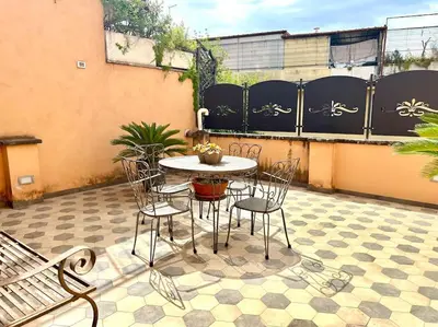 a patio with a table and chairs on a tile floor at Camilla Charme in Rome