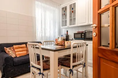 a kitchen with a table and chairs and a couch at Roma Monteverde Apartment in Rome