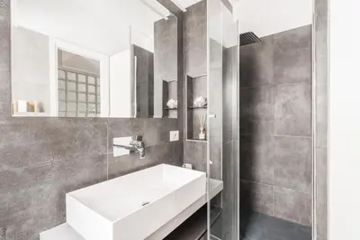 a bathroom with a white sink and a mirror at Elegant Hideaway Steps from St Peter in Rome