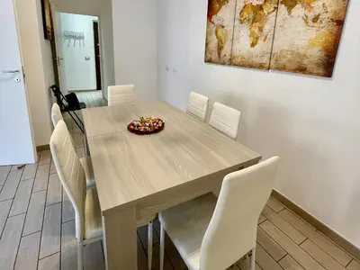 a dining room with a table and white chairs at Domus Laterani by JFM - Comfortable apartment big terrace Colosseo in Rome