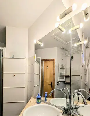 a bathroom with two sinks and a mirror at Cozy Home in San Cosimato in Rome