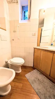 a bathroom with a toilet and a sink and a mirror at Cozy Home in San Cosimato in Rome
