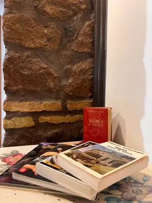 two books sitting on a table next to a wall at Al 25 Trastevere, Roma in Rome