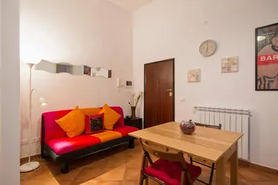 a living room with a red couch and a table at Cozy apartment in Esquilino in Rome