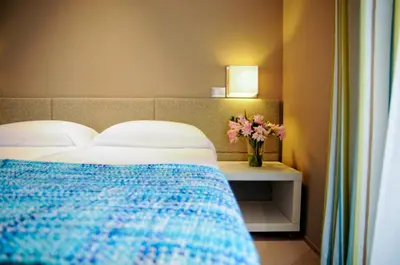 a bedroom with a bed and a vase of flowers on a table at B&B Carini 58 in Rome