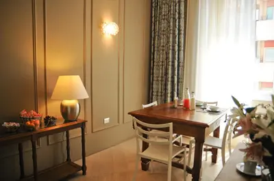a dining room with a table and chairs and a lamp at B&B Carini 58 in Rome