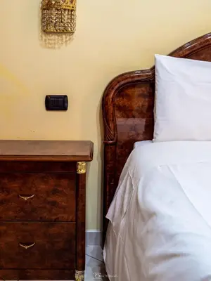 a bedroom with a bed and a wooden dresser at Alla Basilica Rooms in Rome