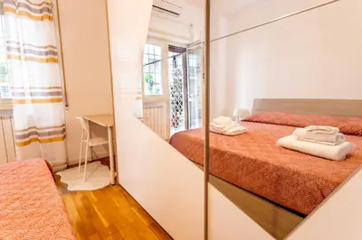 a small bedroom with two beds and a mirror at 