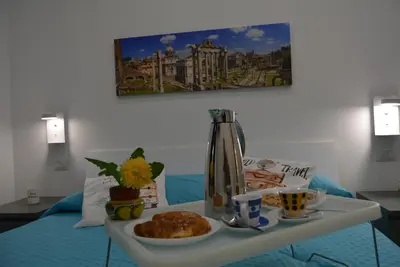 a table with a tray of food on a bed at Casa Amabile in Rome
