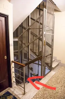 a cage with a red ribbon on the wall at Green house in Rome