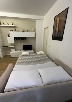 a white bedroom with two beds in it at Appartamento Appio San Giovanni in Rome
