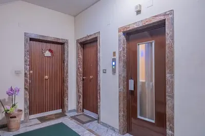 three doors in a hallway with a green rug at Vatican Cozy - Casetta Vaticana in Rome
