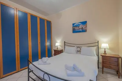 a bedroom with a large white bed and two night stands at Vatican Cozy - Casetta Vaticana in Rome