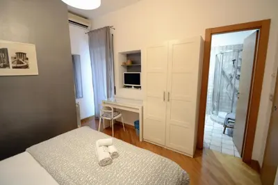 a bedroom with a bed and a desk in it at We Love It - BestBnB Garbatella in Rome