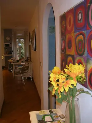a room with a vase with yellow flowers in it at We Love It - BestBnB Garbatella in Rome