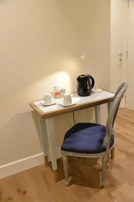 a table with a chair and a tea pot on it at Little Rose Residence in Rome
