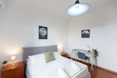 a bedroom with a white bed and a desk with a lamp at Faleria Second by Rental in Rome in Rome