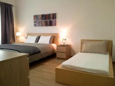 a bedroom with two beds and two lamps and a shelf at Atticoromantica in Rome