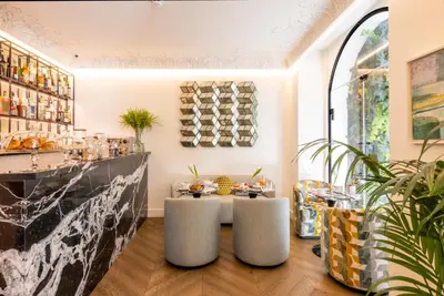 a dining room with a table and two stools at Nerva Boutique Hotel in Rome