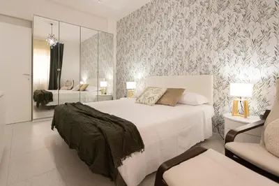 a bedroom with a large white bed and a chair at Carlotta Stylish Apartment Close Tiburtina Station in Rome