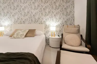 a bedroom with two beds and a chair in it at Carlotta Stylish Apartment Close Tiburtina Station in Rome