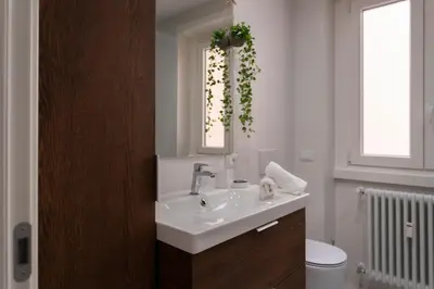 a bathroom with a sink and a mirror and a toilet at Carlotta Stylish Apartment Close Tiburtina Station in Rome