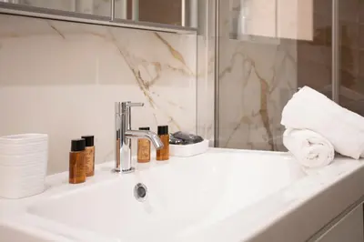 a bathroom sink with a faucet and towels on it at Carlotta Stylish Apartment Close Tiburtina Station in Rome