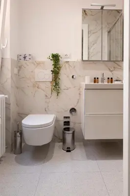 a white bathroom with a toilet and a sink at Carlotta Stylish Apartment Close Tiburtina Station in Rome