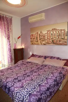 a bedroom with a bed with a purple comforter at Laura's Apartment Vatican in Rome