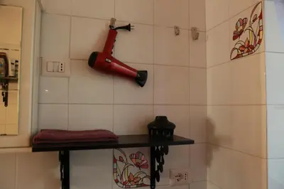 a red hairdryer hanging on a wall at Laura's Apartment Vatican in Rome