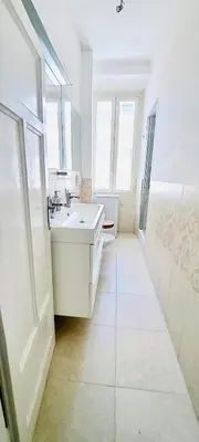 a white bathroom with a sink and a mirror at Cozy Flat near the Vatican! in Rome