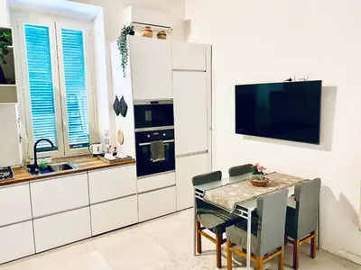 a kitchen with a table with chairs and a tv at Cozy Flat near the Vatican! in Rome