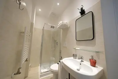 a bathroom with a sink and a shower and a mirror at Roman Forum Holiday Termini in Rome