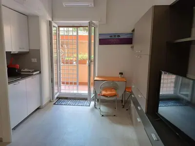 a small kitchen with a table and a door to a balcony at Vatican tiny house by Gialel in Rome