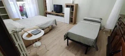 a bedroom with two beds and a table and a tv at Charming Apartment 367 in Rome