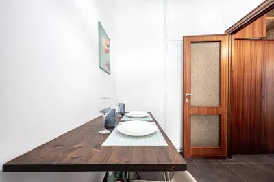 a wooden table with a plate and wine glasses on it at Dream suite Modern in Rome Air Conditioning WiFi near the Metro A in Rome