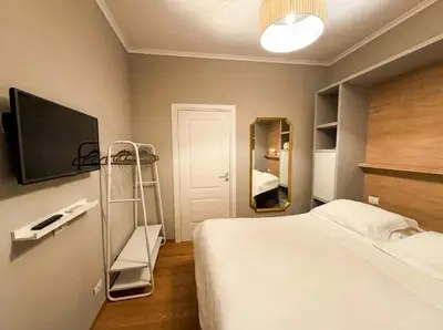 a bedroom with a bed and a tv and a mirror at Gravina Suite Frattina in Rome