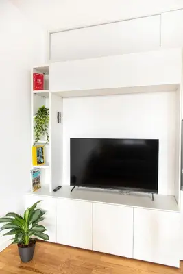 a white entertainment wall with a flat screen tv at Casetta Pandosia - San Giovanni - Colosseo in Rome